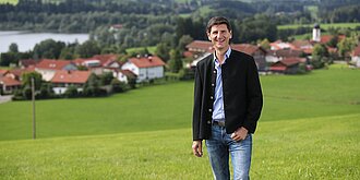 Gerhard Frey steht vor Sulzberg und trägt eine Trachtenjacke